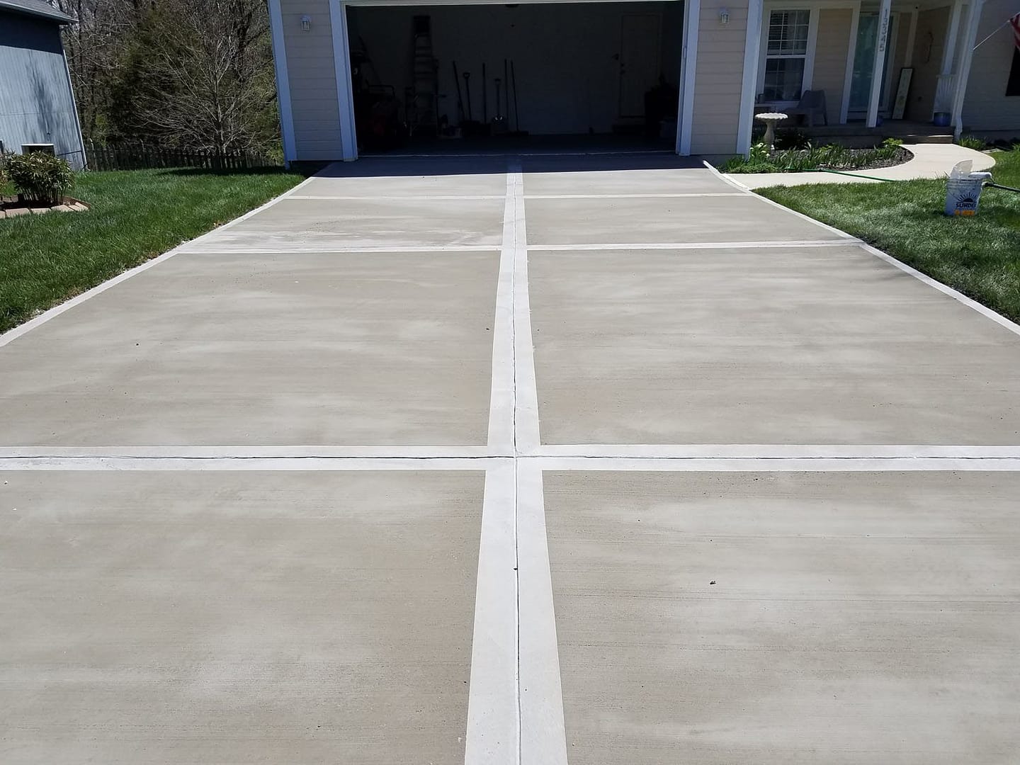 Smooth concrete driveway with joint lines leading to garage in Calgary home
