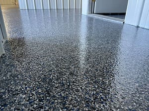 Decorative grey flake epoxy garage floor with glossy protective finish by Tenmen Construction Calgary.